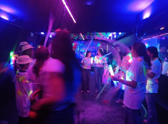 Grupo de adolescentes bailando con luces de colores