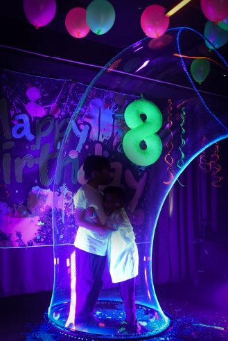 Niña celebrando su cumpleaños en el arco de luz neón de WeGlow, Roma Norte