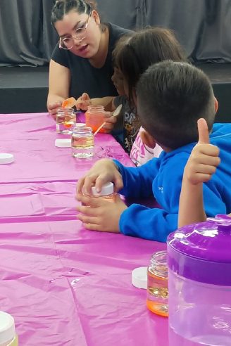 Niños haciendo manualidades guiados por una facilitadora en el Viernes de Consejo de WeGlow